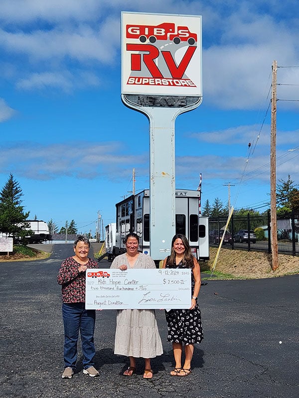 Gib's RV Superstore's Owner Lisa Larkin presenting Sarah and Julie from Kids' Hope Center a check for $2500 from Gib's August Fundraising Promotion.