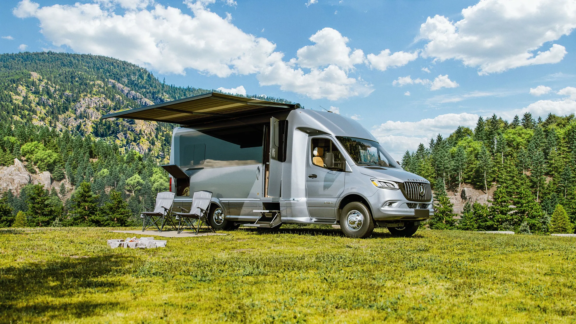 Airstream Atlas with its awning out on a grassy bluff