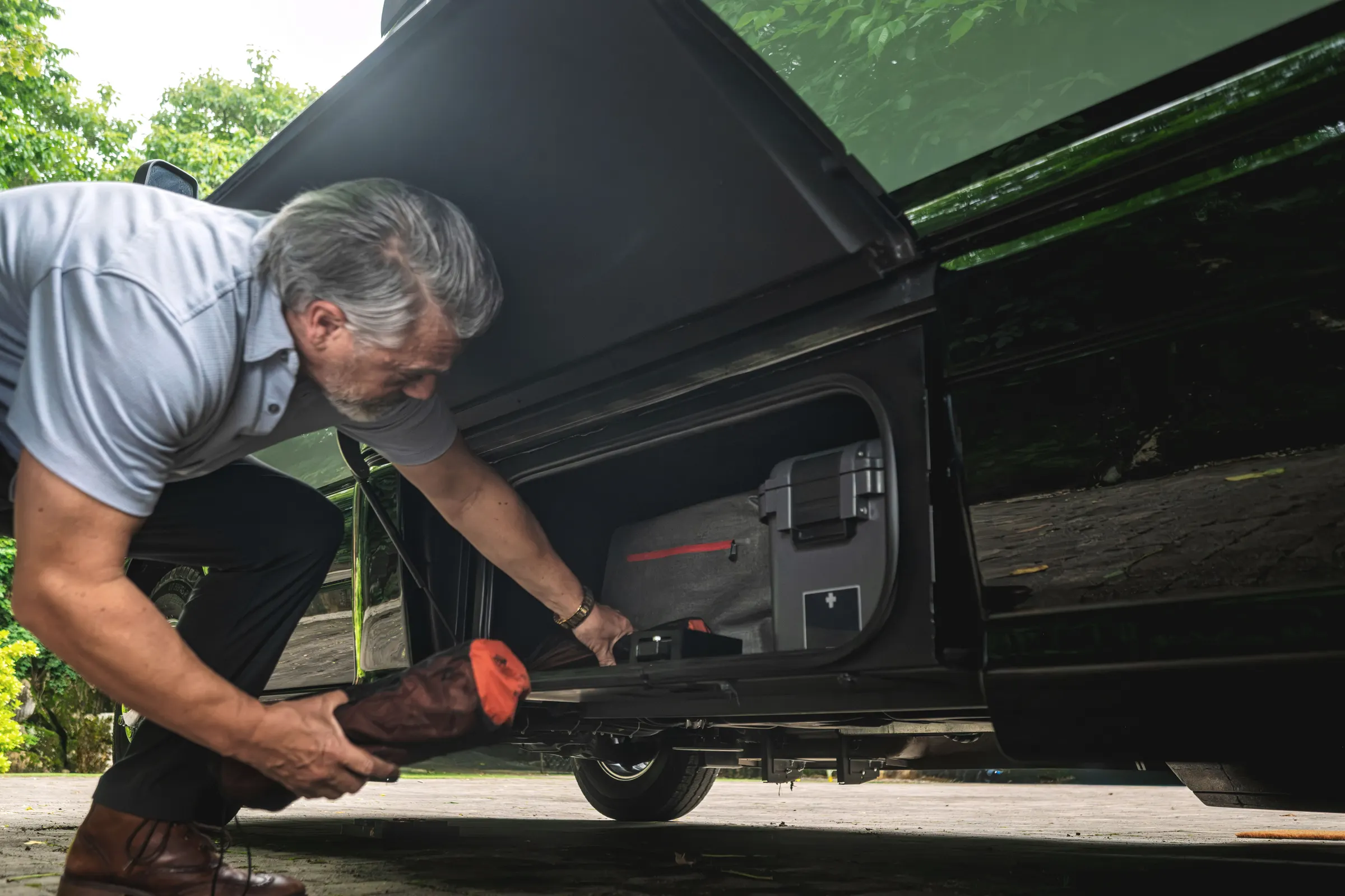 Owner opening a storage hatch on an Airstream Atlas