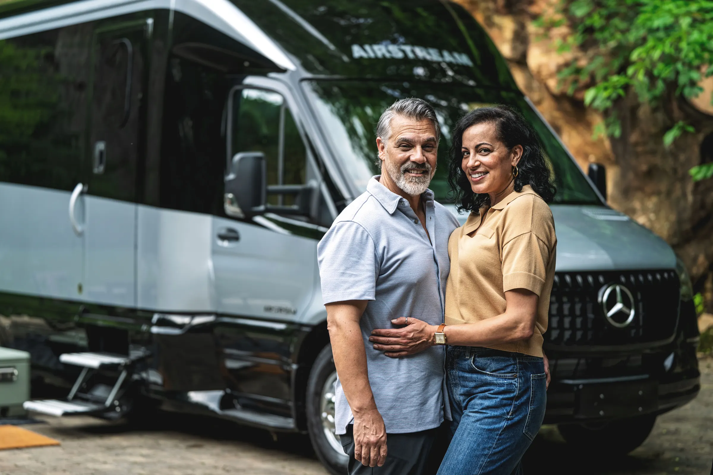 Couple standing beside their Airstream Atlas