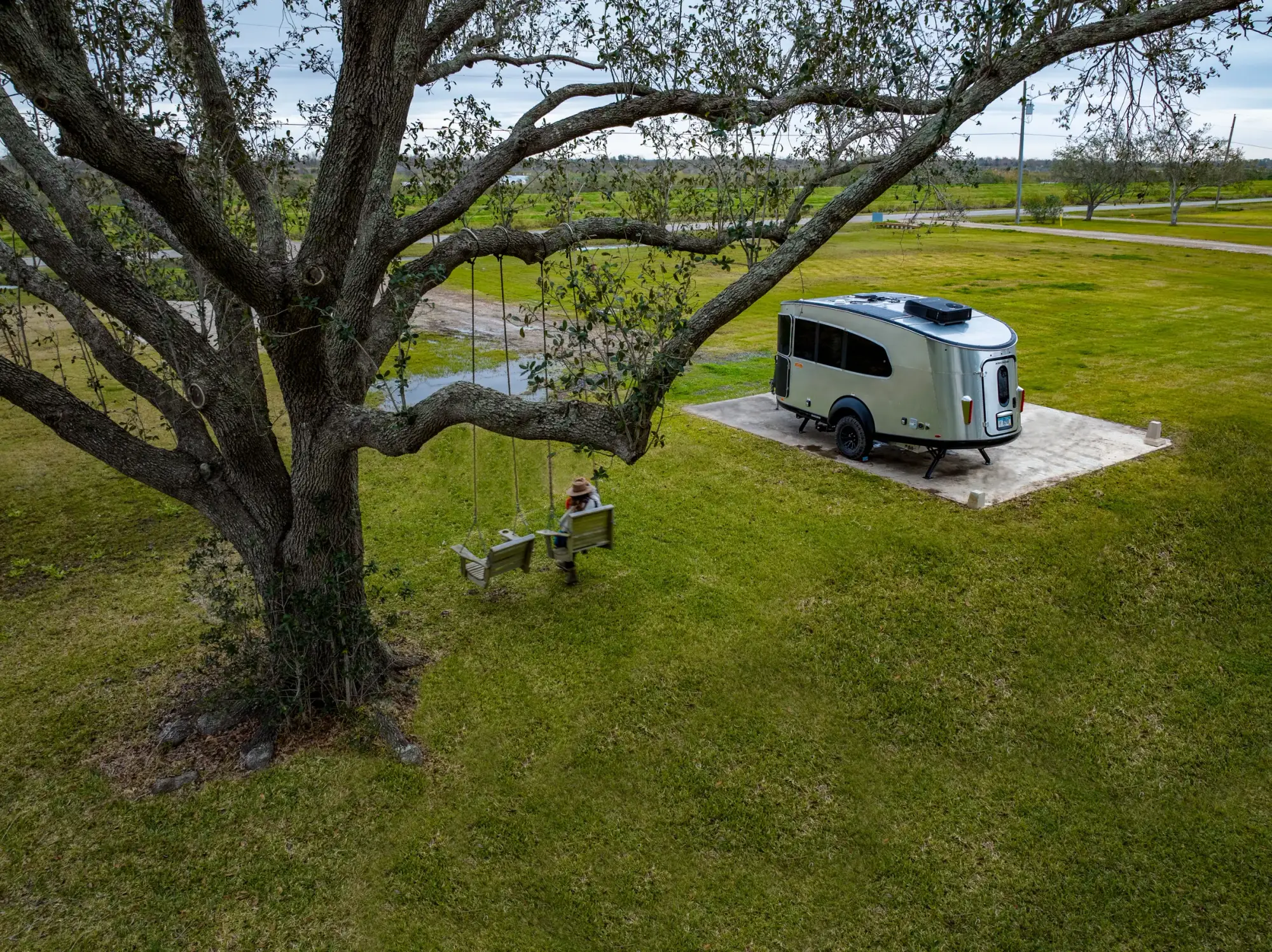 Airstream Basecamp parked beneath a spreading oak