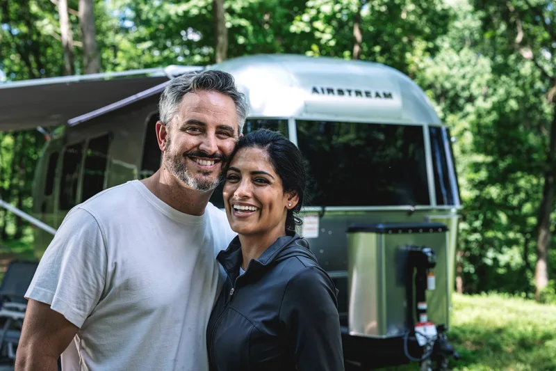 Couple in front of their Airstream Flying Cloud