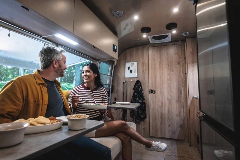Couple sharing a meal inside an Airstream Flying Cloud