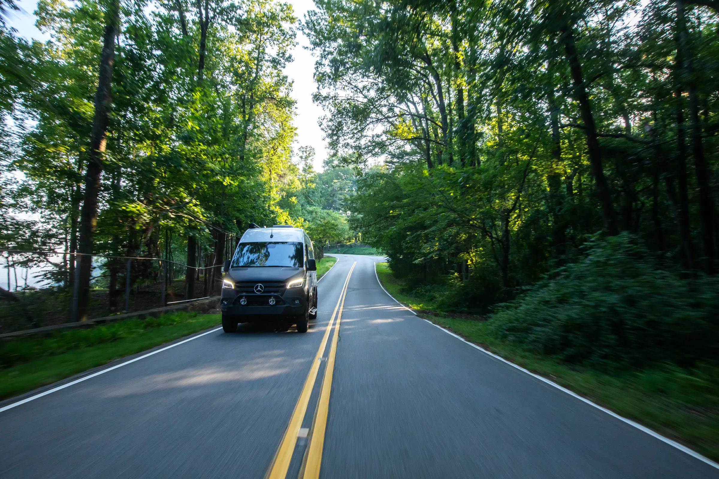 Airstream Interstate on a tree-lined road